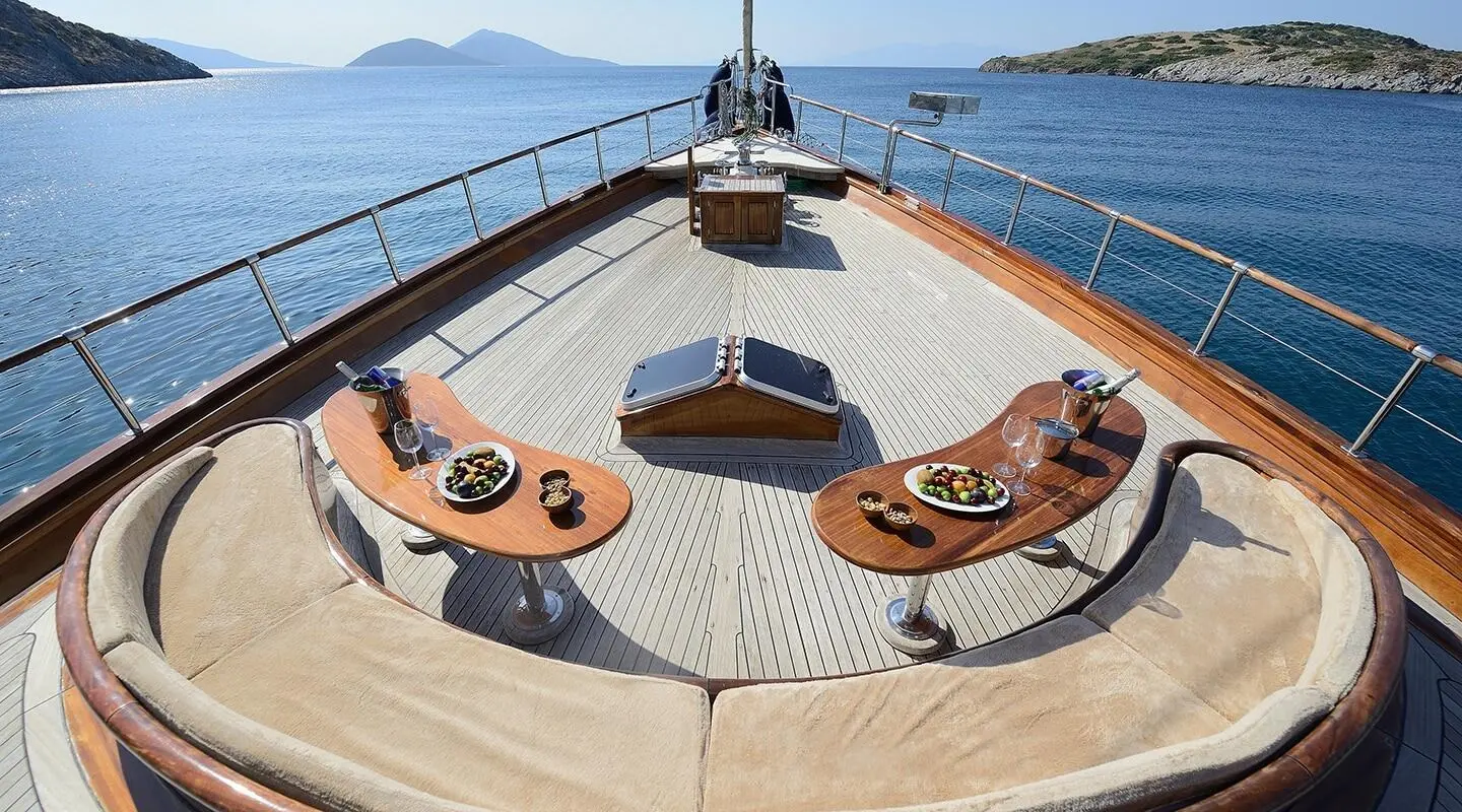 Zephyria II atop a yacht bow with lounges and sun deck at sunset on calm sea