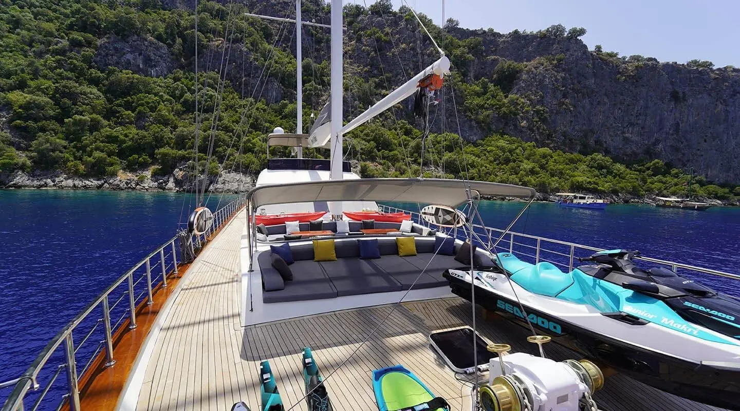 Queen Of Makri yacht deck with colorful sunbeds and clear blue sea