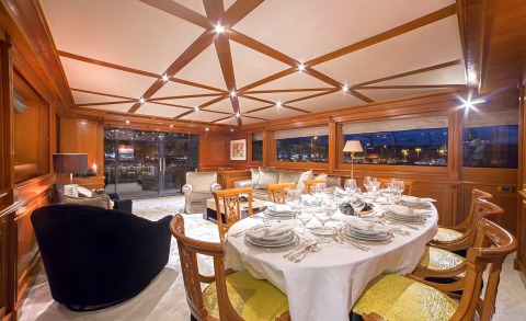 Aquila motor yacht dining area with tables and chairs set with white linens