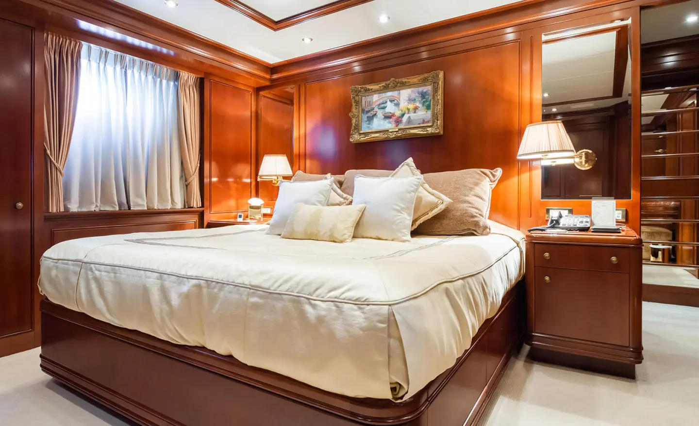 Interior cabin on Apogee yacht with two beds, wooden walls, and bedside lamps