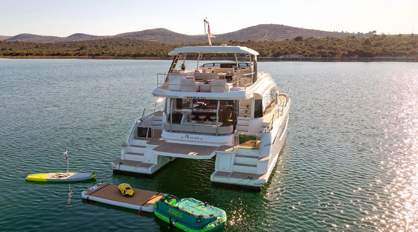 Yacht By My Side anchored near clear water with water toys nearby