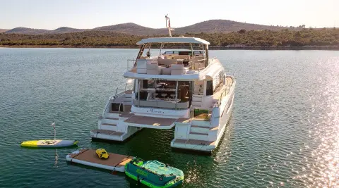Yacht By My Side anchored near clear water with water toys nearby