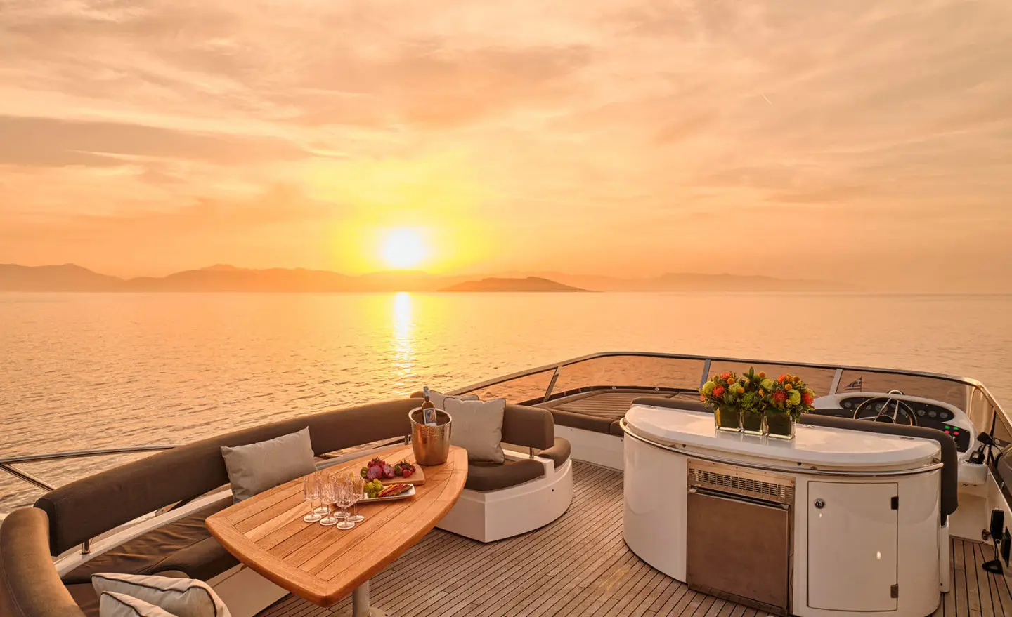 Sunset on a luxury yacht deck with seating and a small table