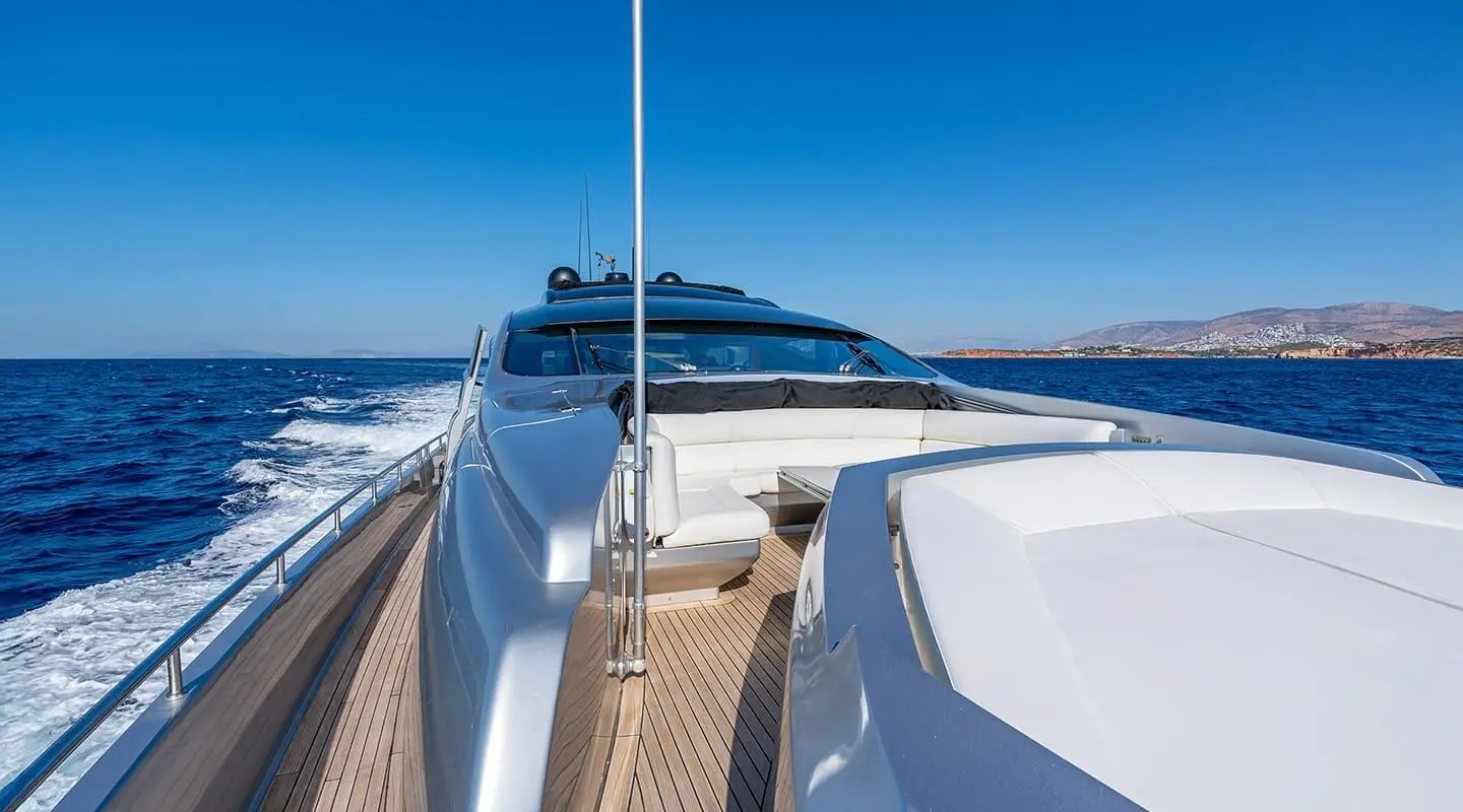 From deck looking forward on luxury yacht One, polished wood, railings, and blue sea horizon