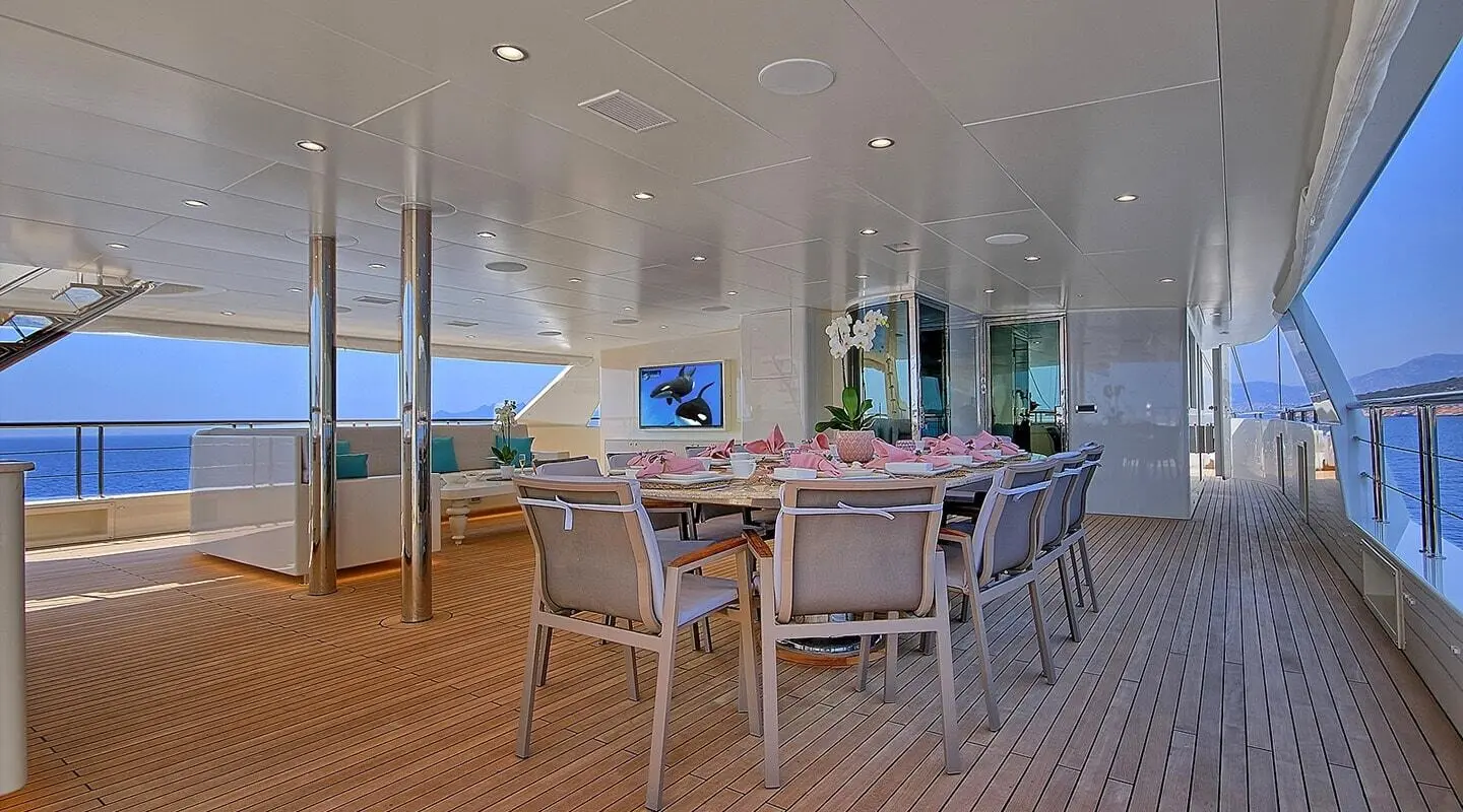 Meira yacht dining deck: wooden table and chairs under a white canopy