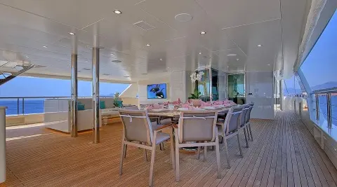 Meira yacht dining deck: wooden table and chairs under a white canopy
