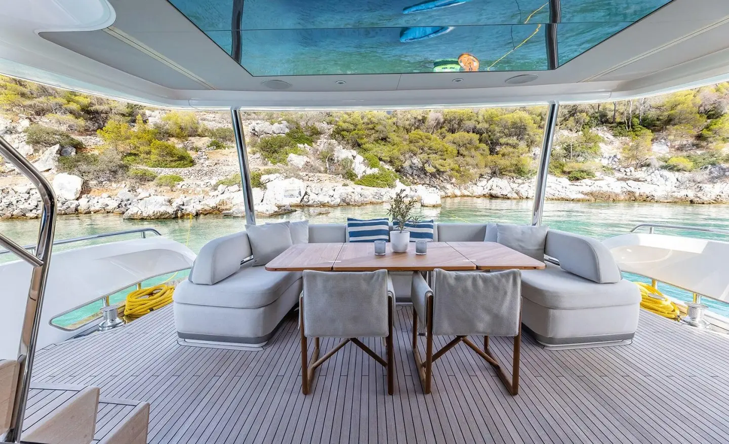 Vista yacht deck dining area with curved white seating and small table, ocean view