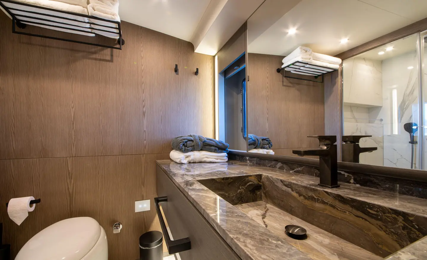Luxurious ensuite bathroom on Good Life yacht with marble counter and towels