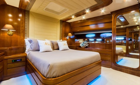 Amoraki yacht interior with double cabin, wooden furniture, cabinets and soft lighting in the bedroom