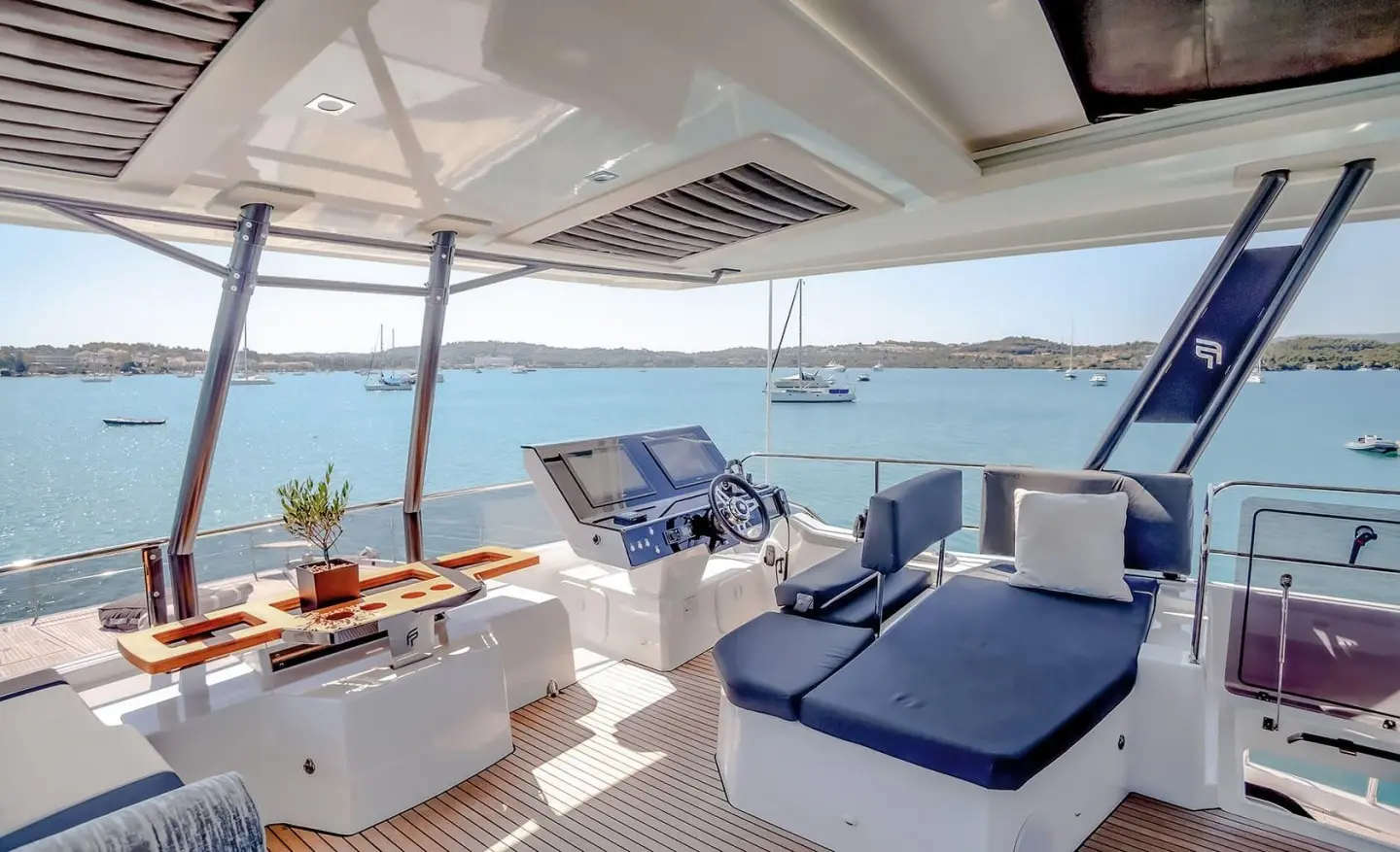 D2 motor yacht deck with sun loungers and seating overlooking calm sea