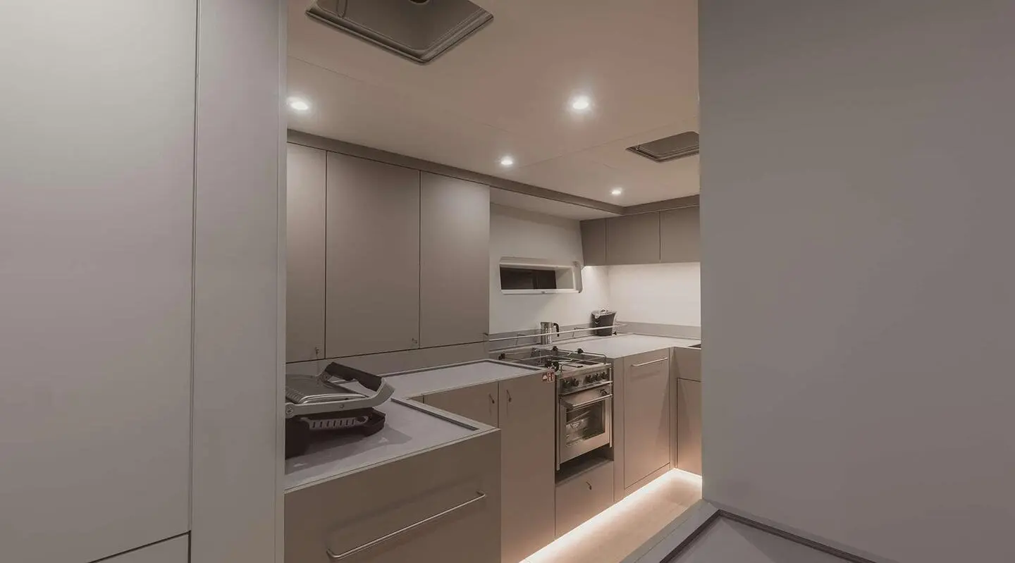 Nadamas yacht cabin kitchen area with counter, cabinets, stove and lighting