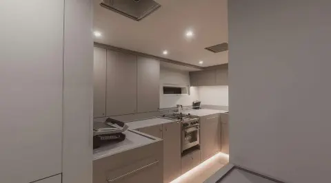 Nadamas yacht cabin kitchen area with counter, cabinets, stove and lighting