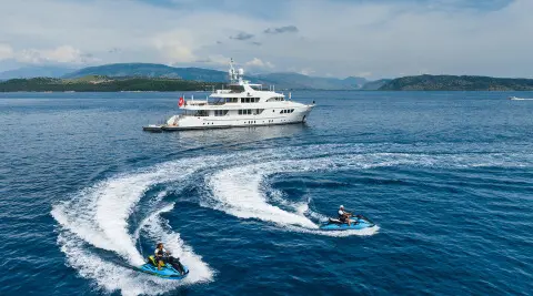Serenity yacht sailing on blue sea with wake, sleek white hull, clear sky