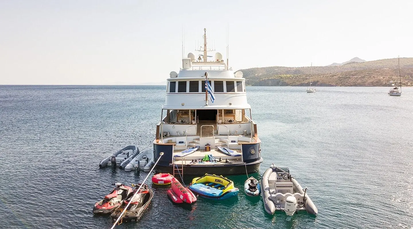 Wind Of Fortune yacht docked with small boats aboard and calm sea