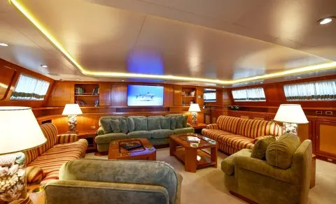 Tamarita yacht salon interior with leather seating, wood paneling, and blue-lit screens