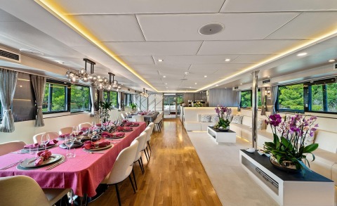 Motoryacht Freedom interior with a long dining table and seating, modern decor.
