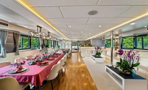 Motoryacht Freedom interior with a long dining table and seating, modern decor.