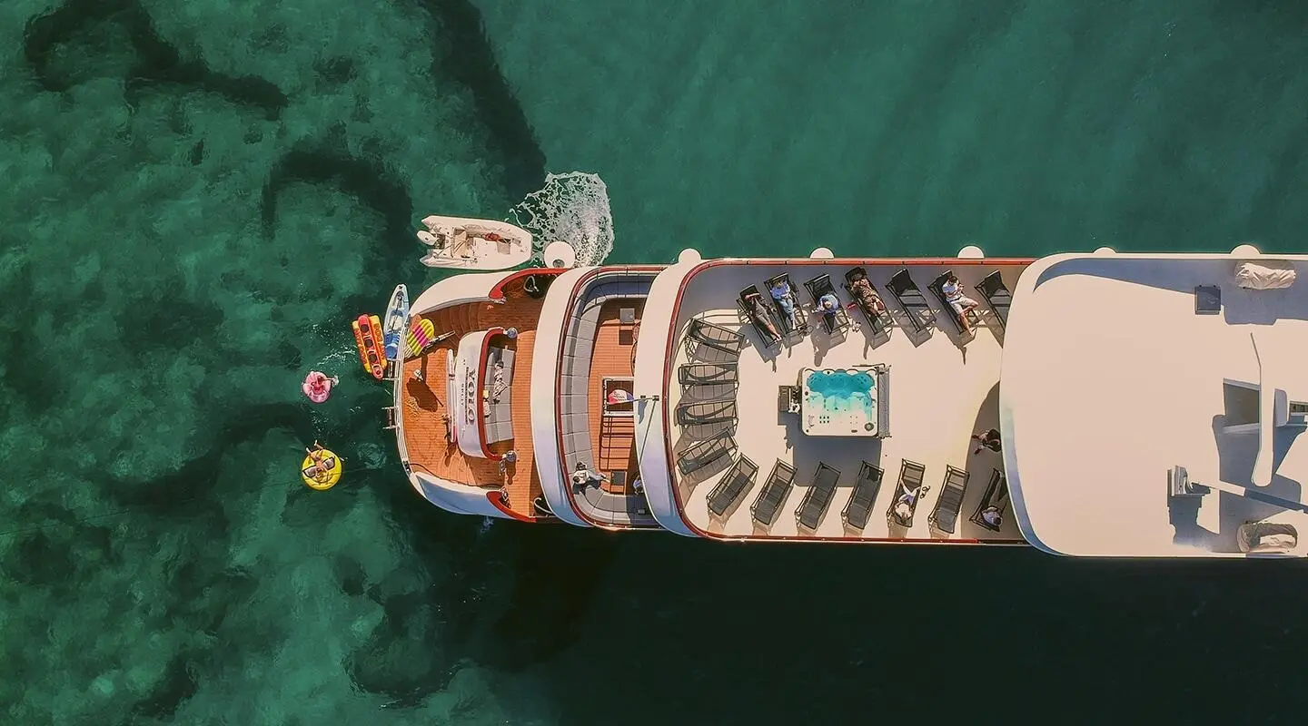Aerial view of a motor yacht named Yolo docked by a pier, sunny day