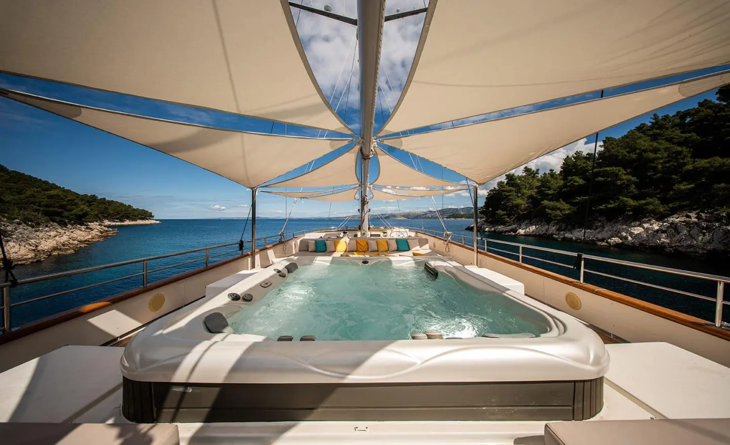 Dalmatino yacht deck at sunset over blue sea, forward sunshade, hot tub area