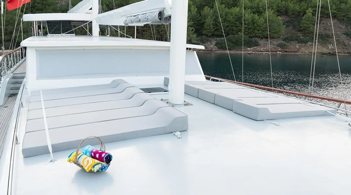 Vista Mare yacht deck at sunset with white sofas and calm water backdrop