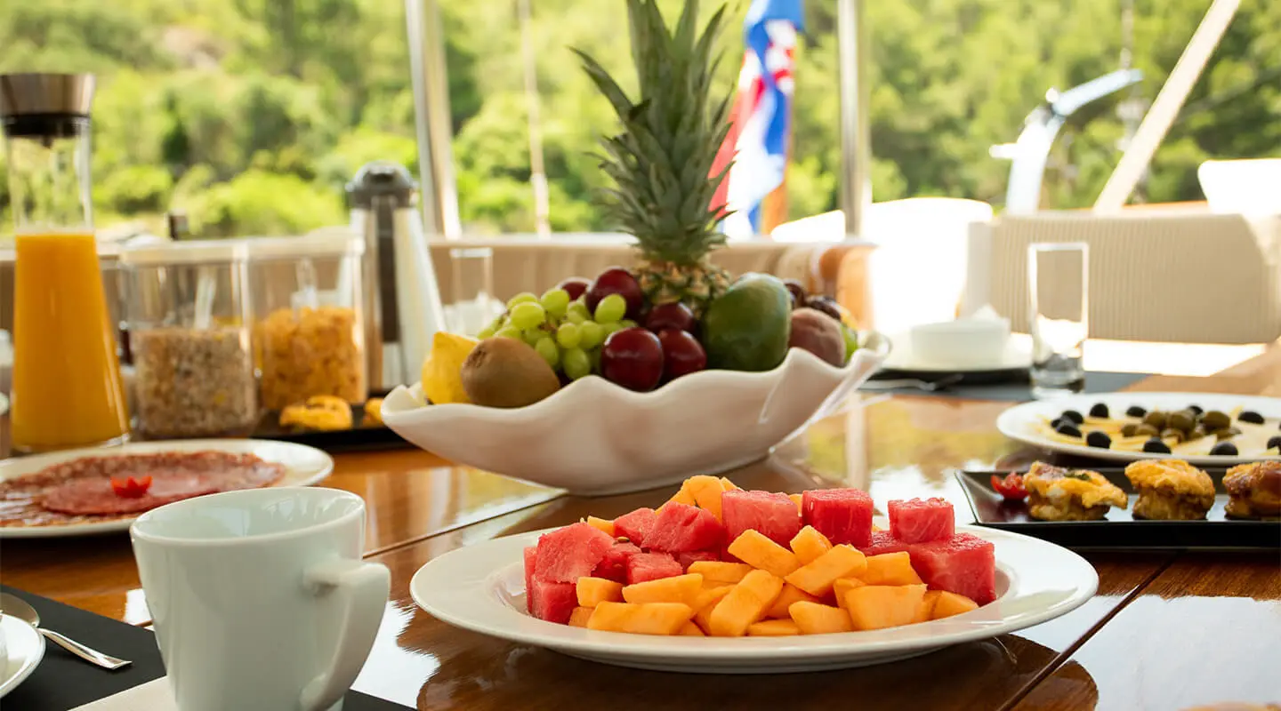 Dolce Vita yacht dining on deck with fruit bowl and fresh juice