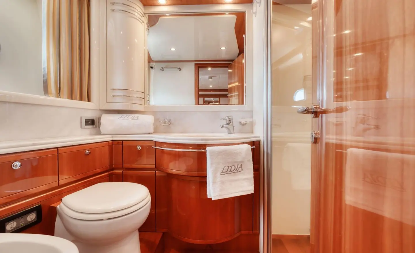 Bathroom on the Lidia yacht with a wooden vanity, sink, and mirrored cabinets