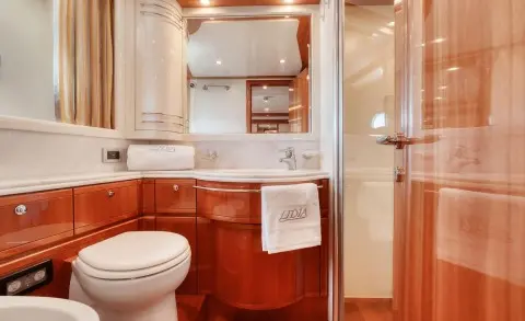 Bathroom on the Lidia yacht with a wooden vanity, sink, and mirrored cabinets
