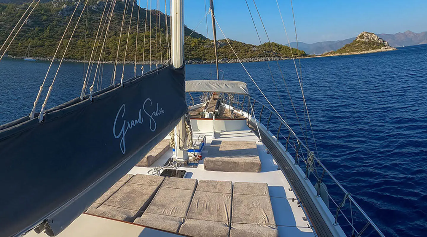 Deck of Grand Sailor gulet with sun loungers and ropes along railing