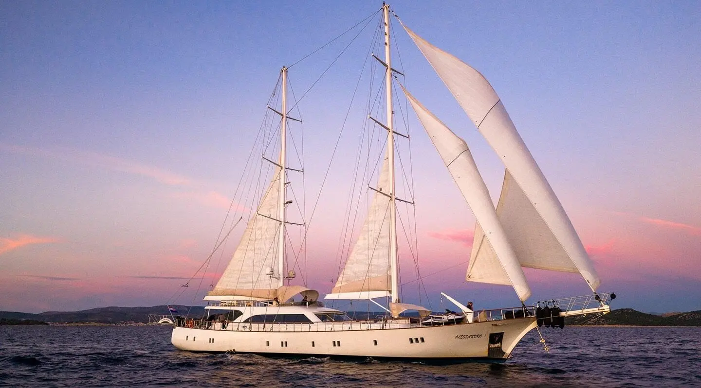 Alessandro I luxury sailing yacht anchored at sunset with billowing sails