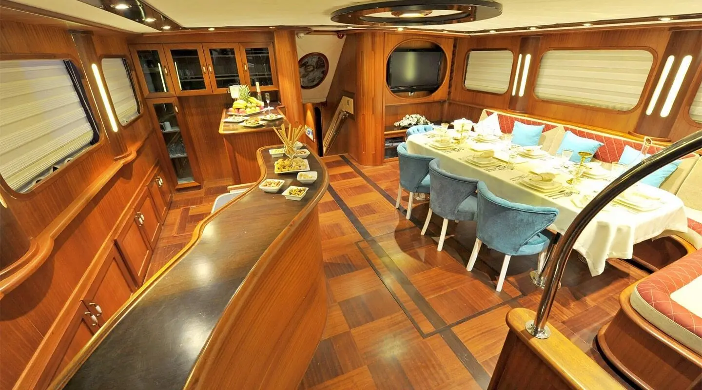 Gulet Berrak Su interior with wooden deck, seating and table