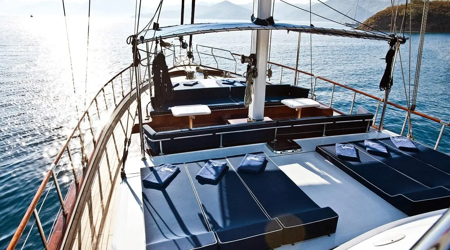 Maske 2 yacht deck with blue cushions and railing at sunset harbor