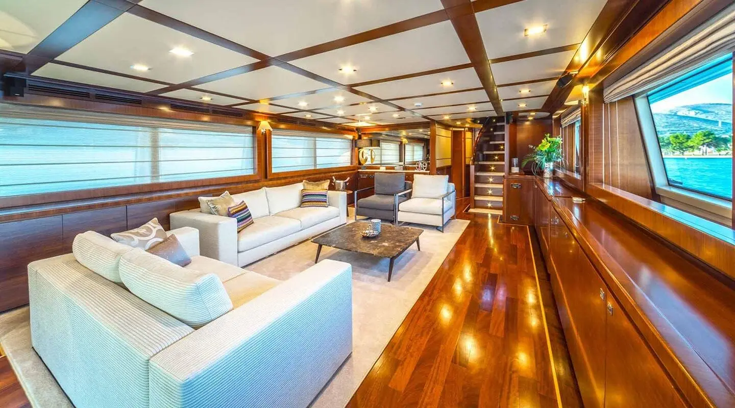 Seventh Sense yacht saloon interior at sunset with leather seating and polished wooden floor