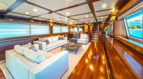 Seventh Sense yacht saloon interior at sunset with leather seating and polished wooden floor
