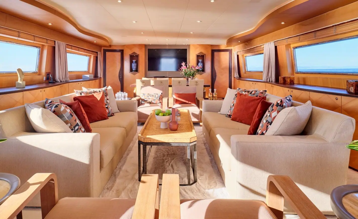 Luxurious Mobius yacht salon with cream sofas, red cushions, and wood accents