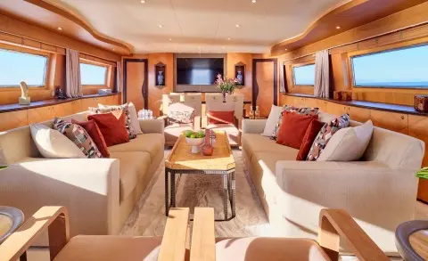 Luxurious Mobius yacht salon with cream sofas, red cushions, and wood accents
