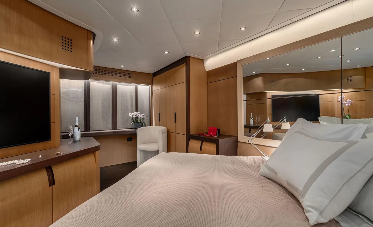 Luxurious yacht interior bedroom with large bed, built-in storage, and ambient lighting
