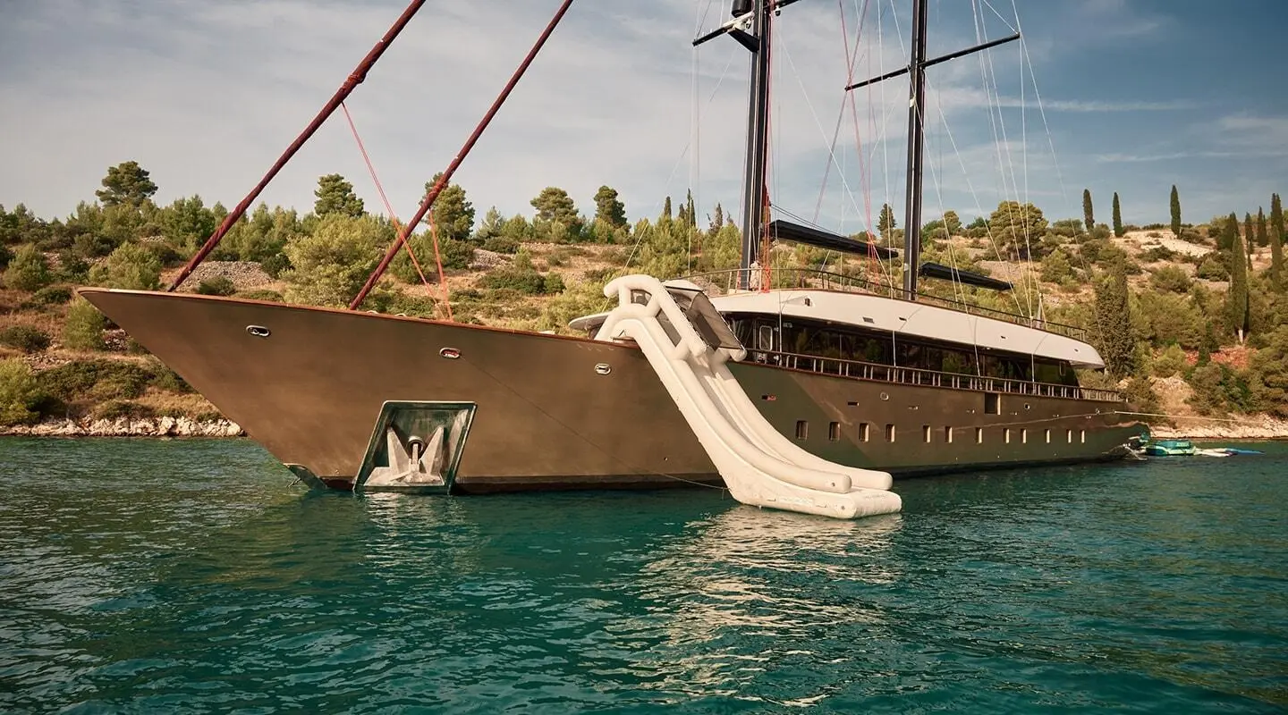 Anetta yacht moored at a dock with a gangway leading to the water, sunset sky