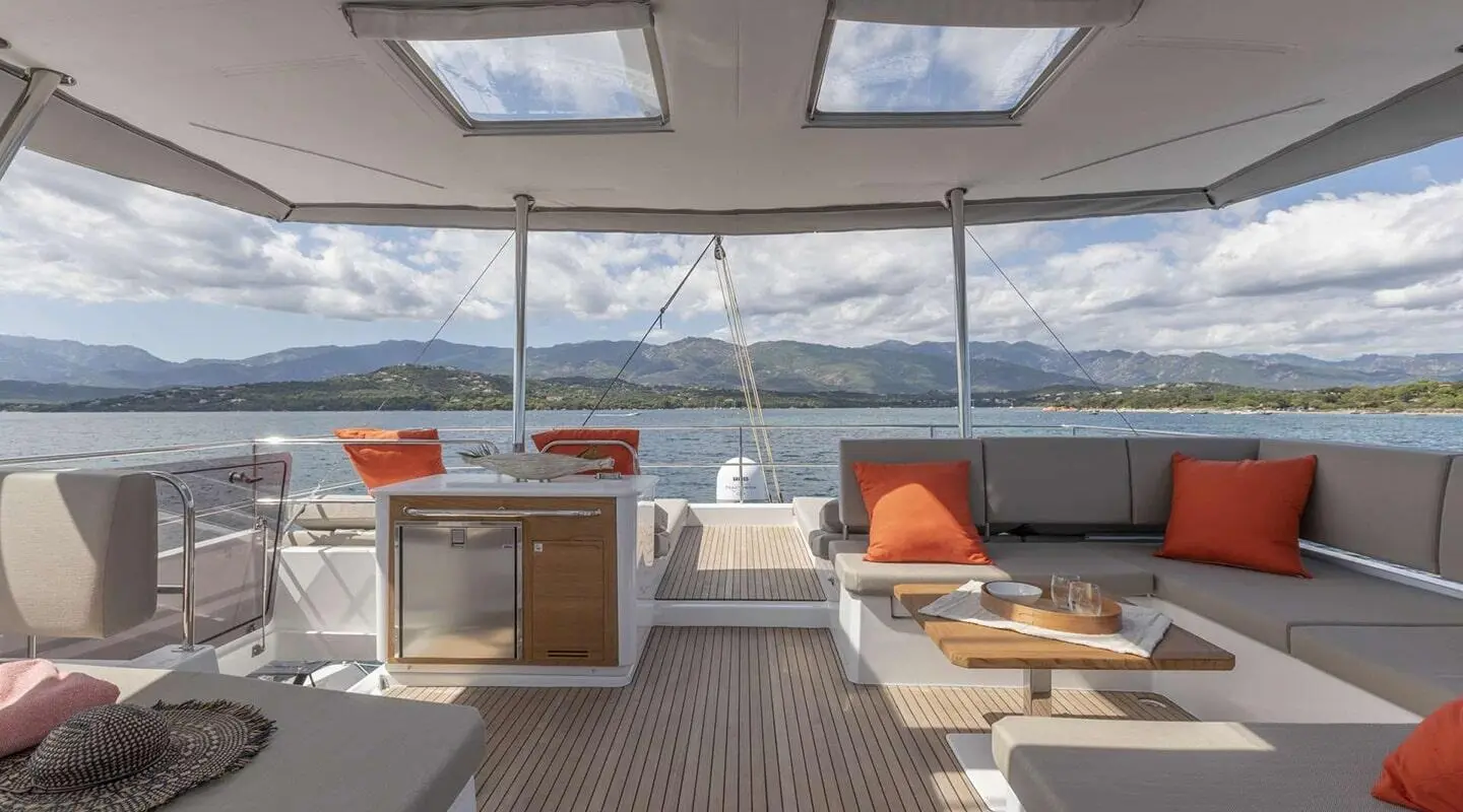 Serenissima yacht aft deck view with seating, orange cushions, railing, and ocean backdrop