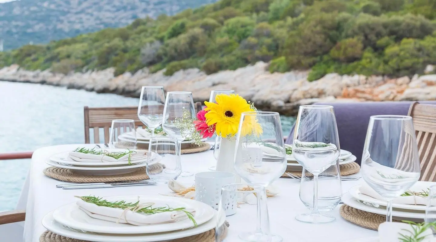 Primadonna yacht at a seaside table setup with sunflowers and sunset glow