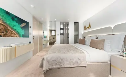 Maxita luxury yacht bedroom with large bed, neutral tones, and seating area