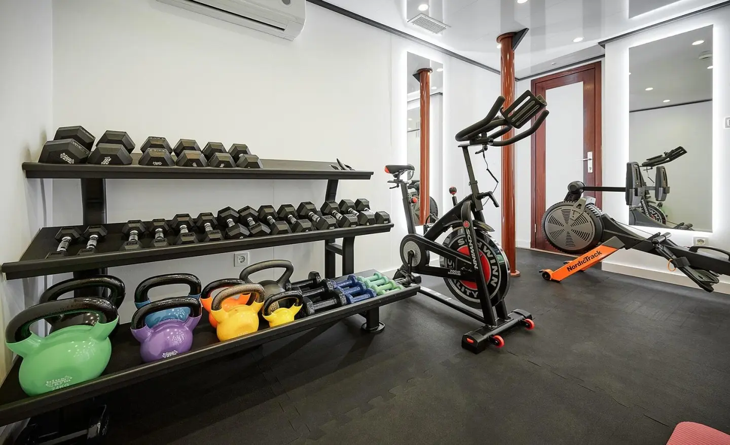Fitness room aboard Lupus Mare with free weights and exercise machines