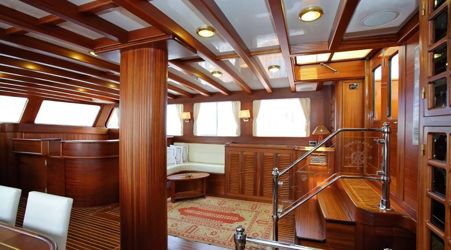 Interior of Kaya Guneri 4 gulet saloon with wooden paneling and windows