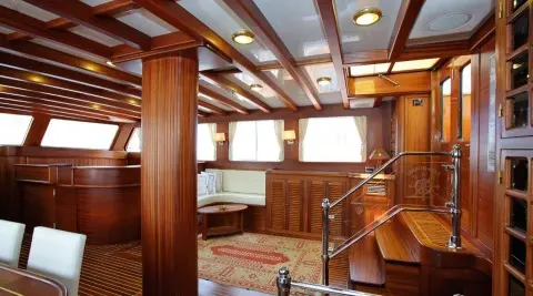 Interior of Kaya Guneri 4 gulet saloon with wooden paneling and windows