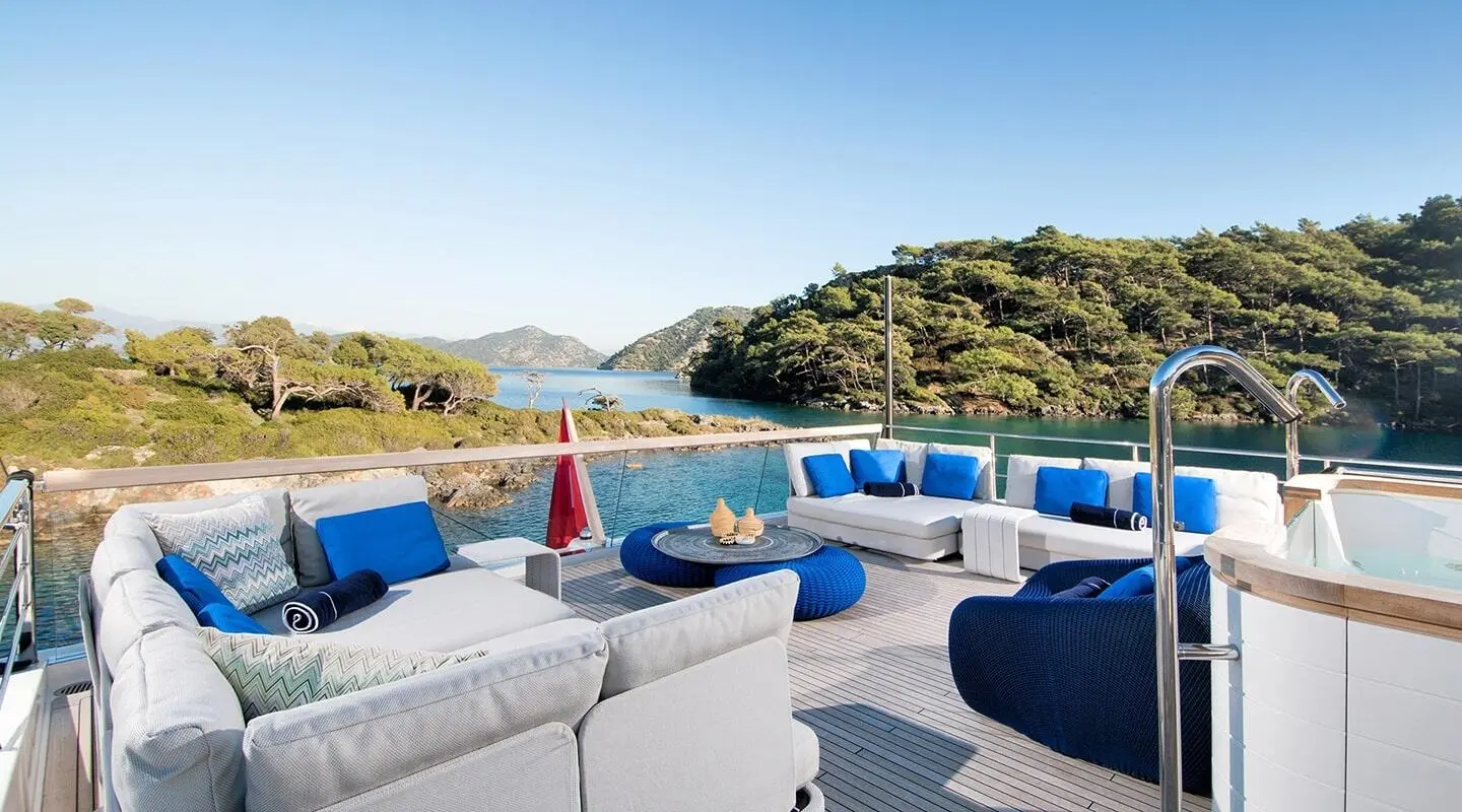Morning Star yacht deck with blue lounge seating and white cushions on sunny day