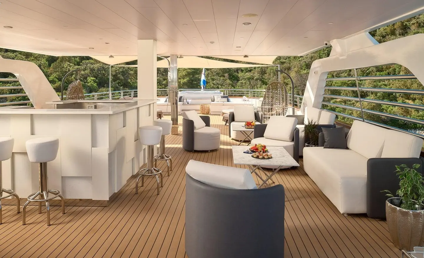 Cristal yacht deck seating area with white and gray furniture at sunset