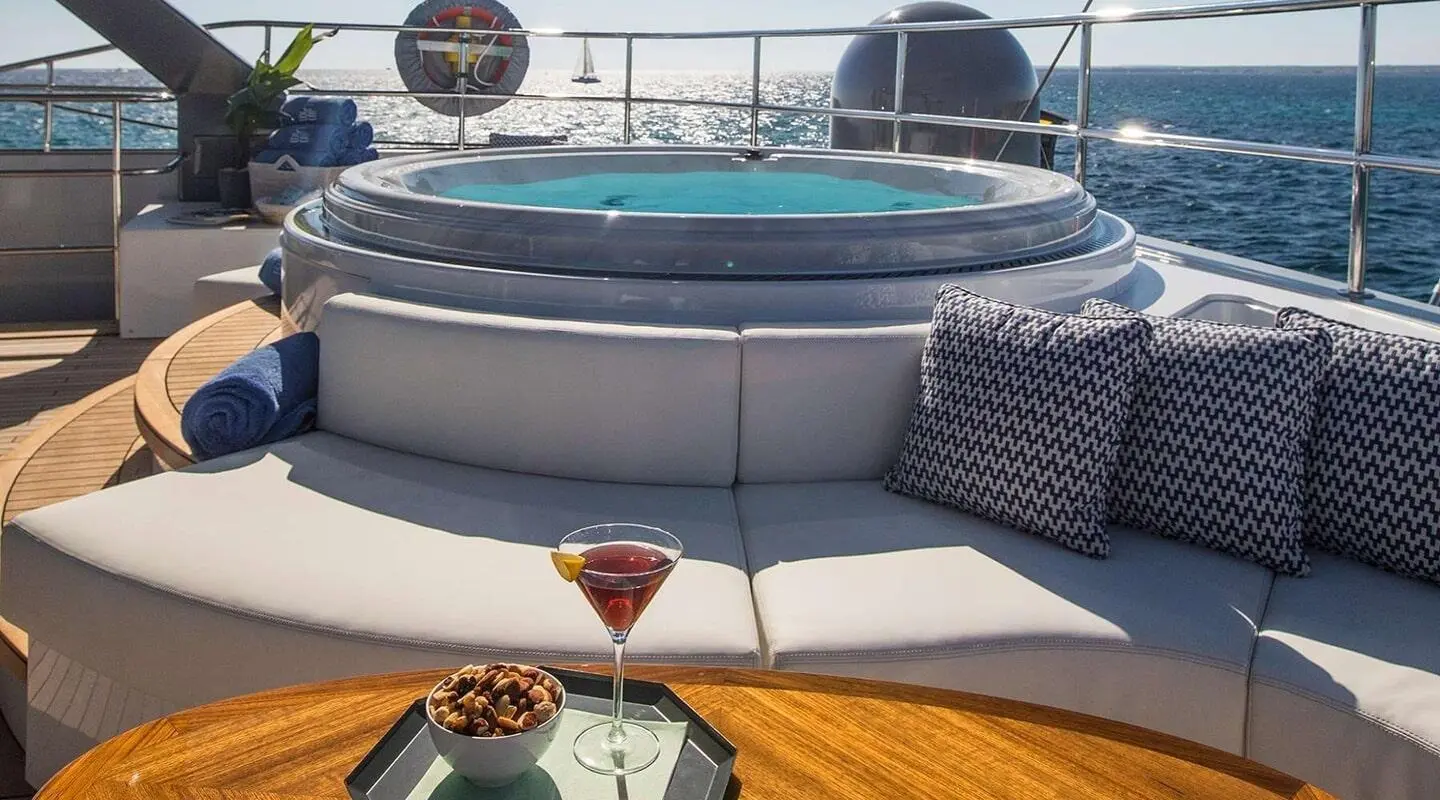 Cartouche yacht aft deck seating with hot tub and sunset over calm sea