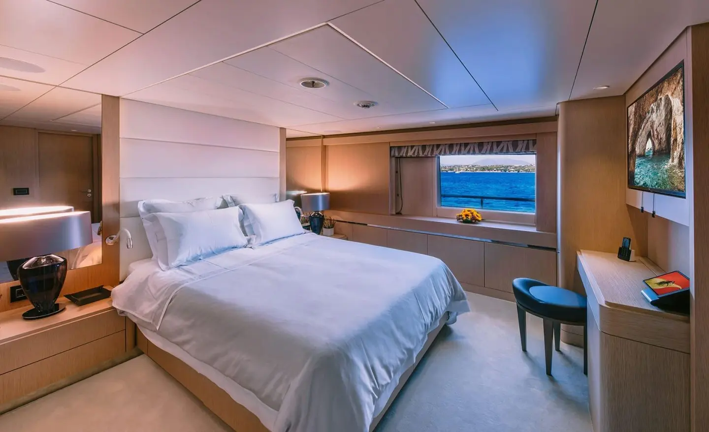 Luxurious cabin aboard Xana with two single beds, soft lighting, and a window view