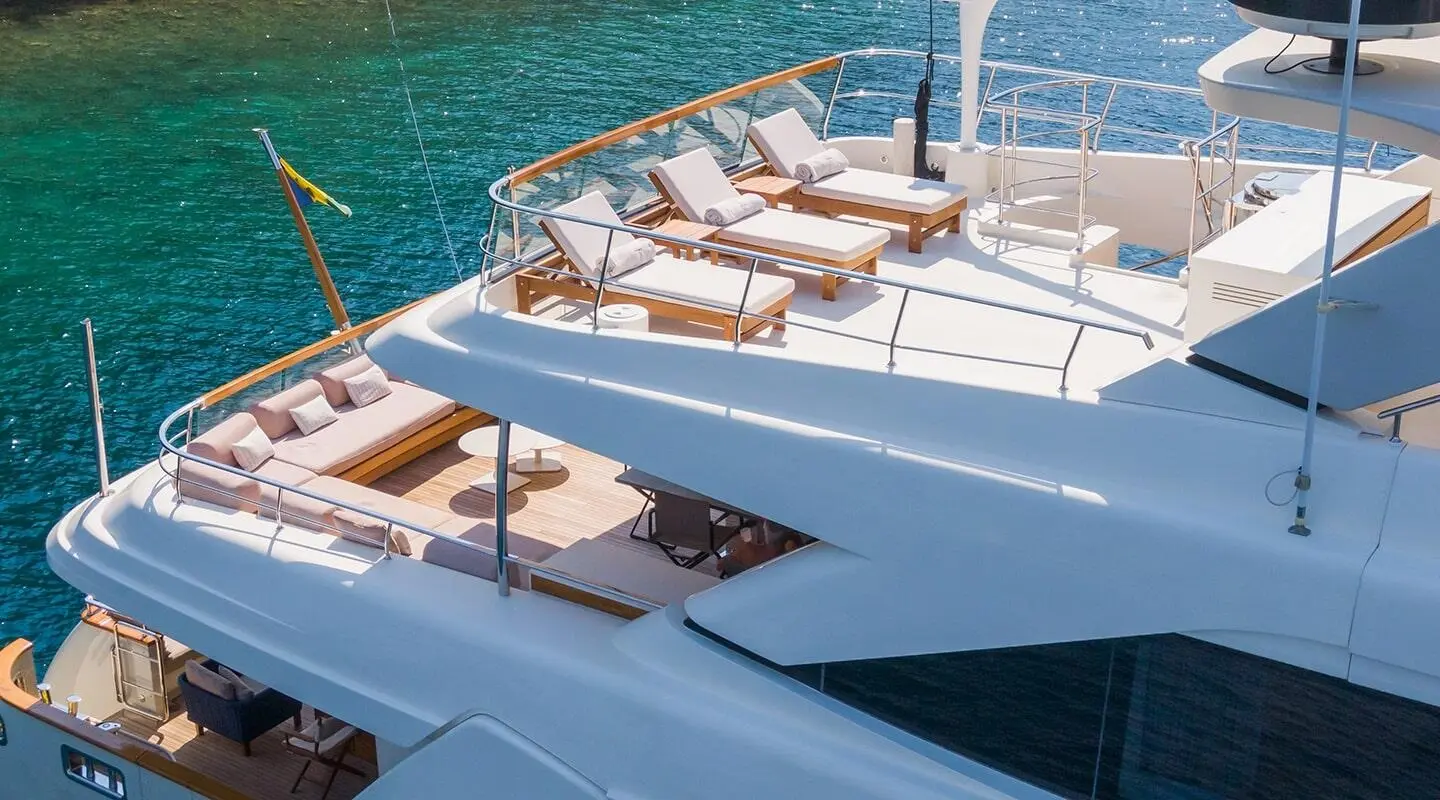 Takara One yacht's upper deck with seating area and railings above blue water