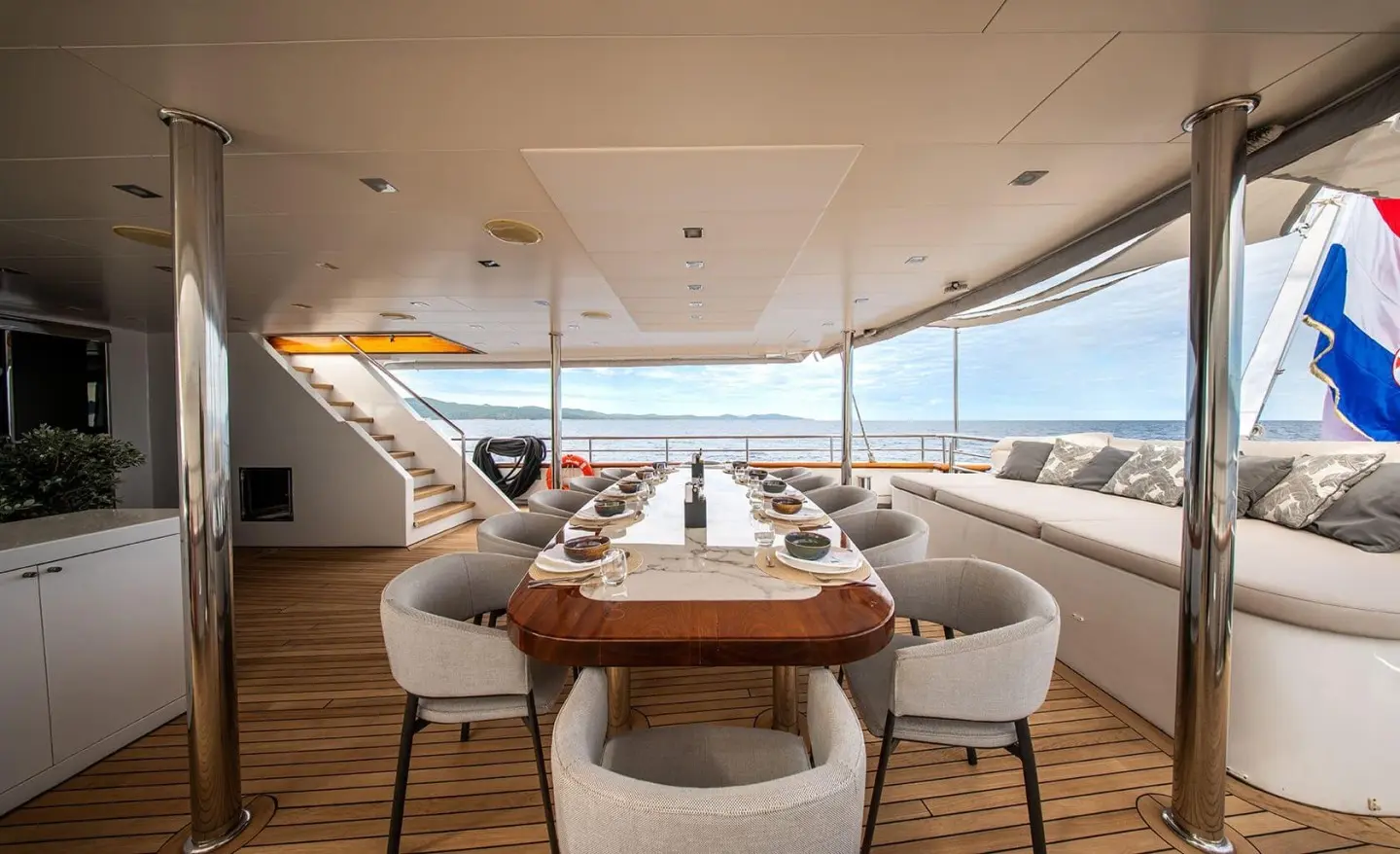 Dalmatino yacht deck dining area with table and chairs under a covered helm