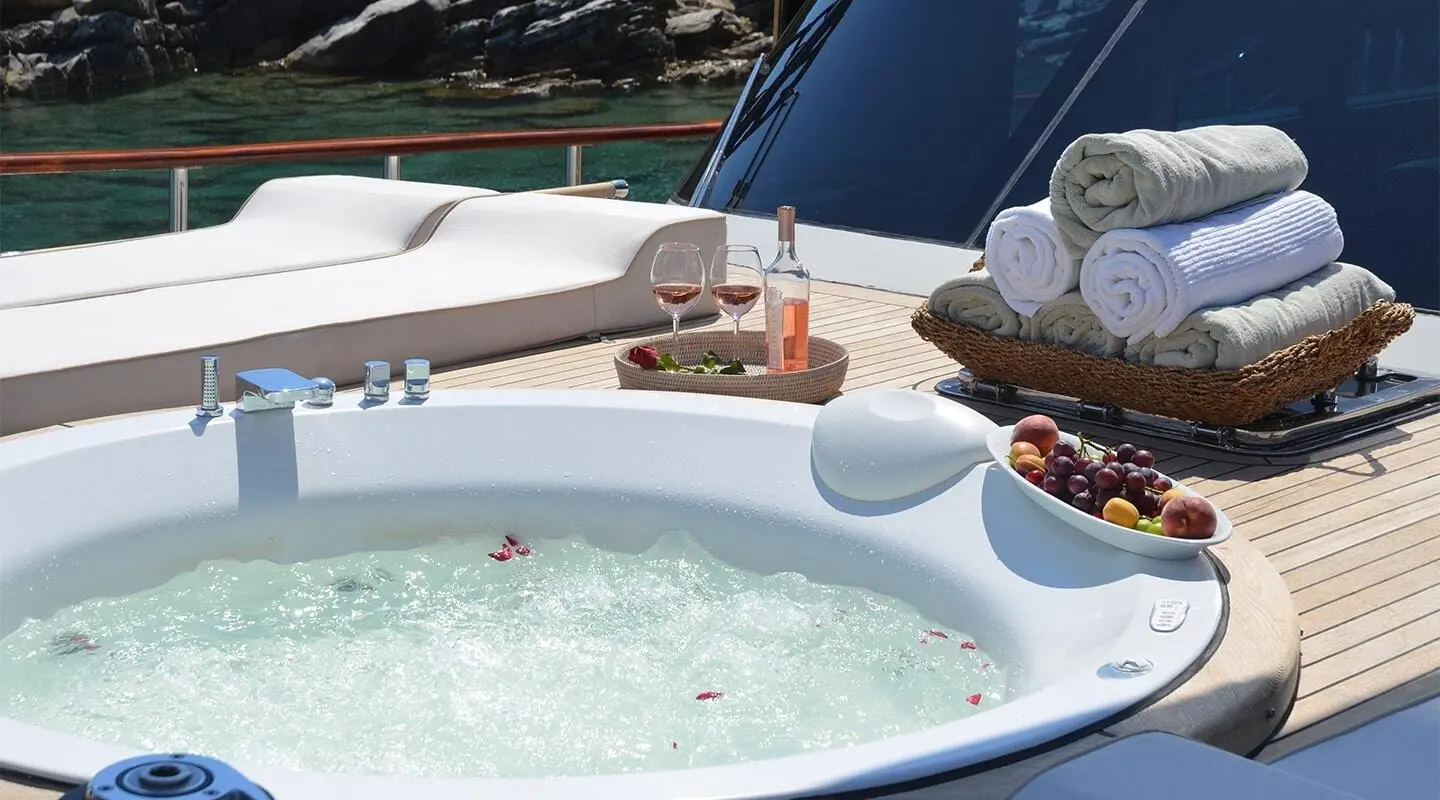 Blue Heaven luxury yacht hot tub on deck with towels, wine, and fruit basket
